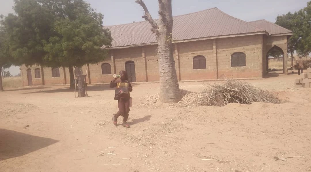 A boy walks in front of Global Mission Church, Gidan Haruna
