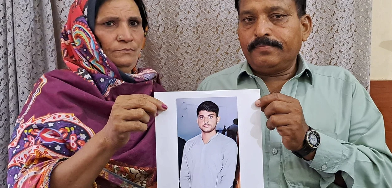 The parents of Noman Masih hold up his picture. csi
