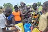 A group of women hold out bags to receive food aid in South Sudan. csi