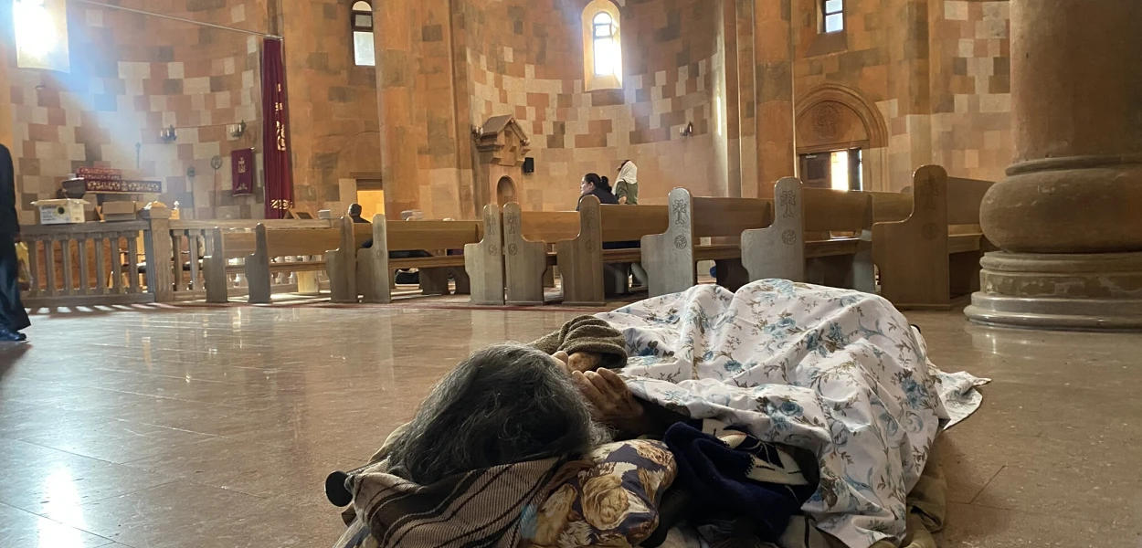 A displaced woman sleeps in the main cathedral in Stepanakert. csi/Siranush Sargsyan