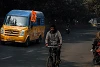 A cyclist rides past a van flying one of the ubiquitous saffron flags. csi