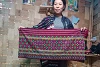A participant in the weaving program shows off her work. csi